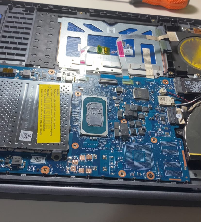 Notebook aberto na bancada da Lipe Tech, com a placa-mãe exposta